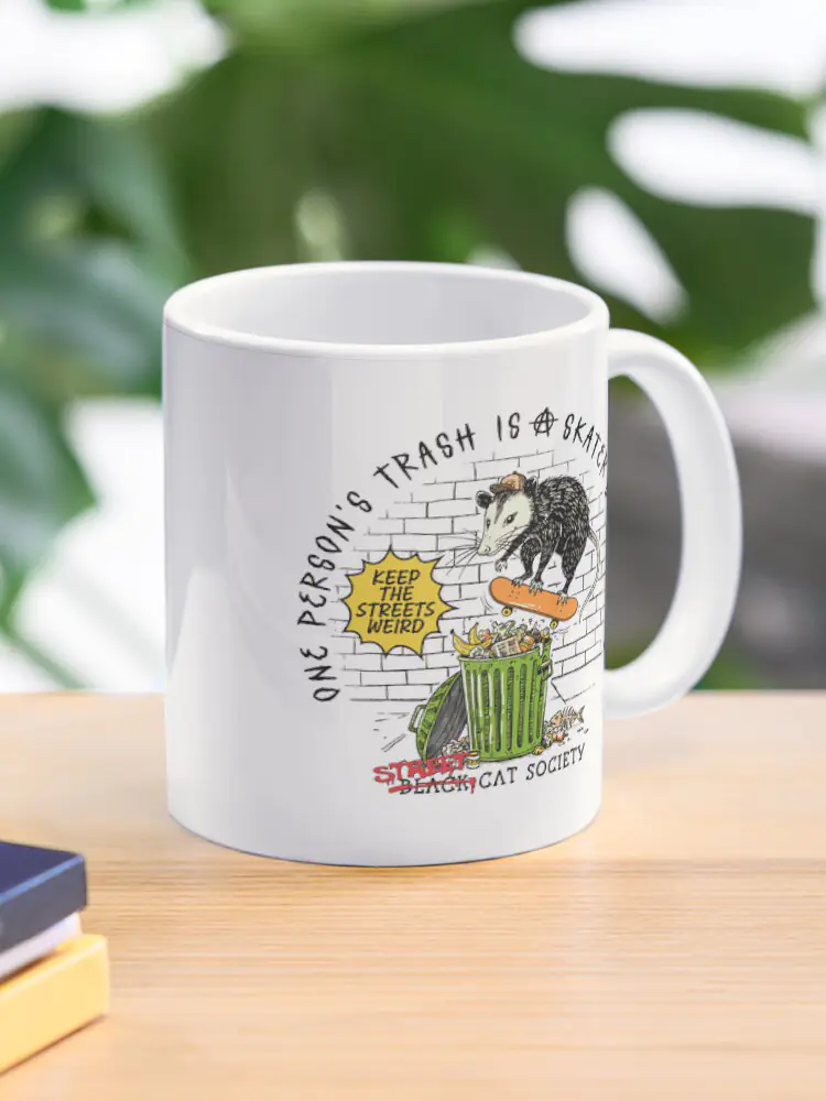 A white ceramic coffee mug with a wrap-around print of the skateboarding opossum, a funny gift for fans of "trash animal" humor.