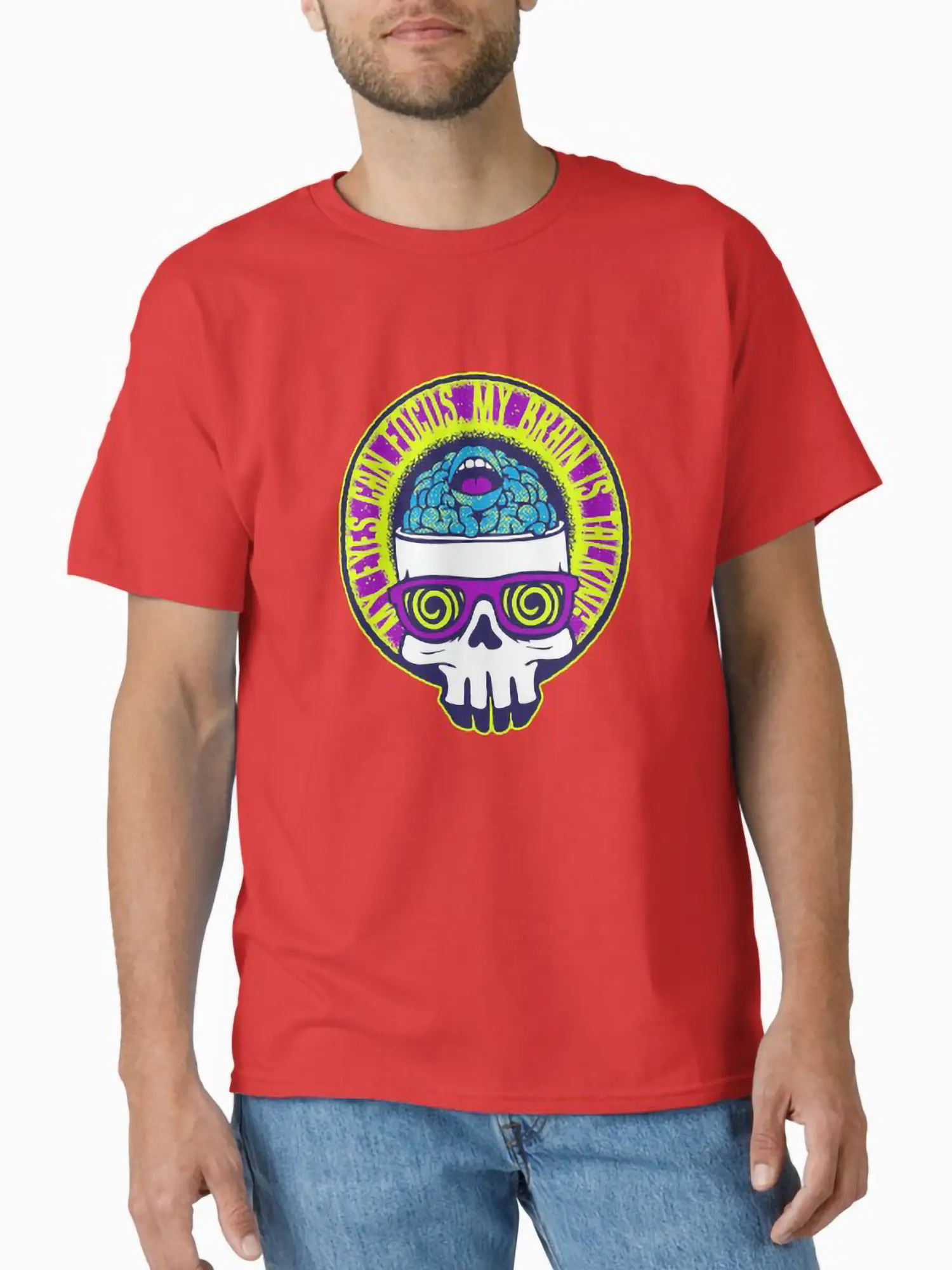 A man wearing a red short-sleeve t-shirt with a central trippy skull graphic, showcasing the 90s art-punk aesthetic and vibrant color contrast of the design.