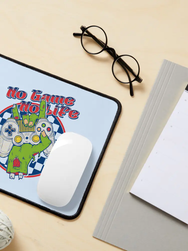 A large, textured gaming mousepad with a "retro zombie controller" print, positioned on a wooden desk with a minimalist PC setup.