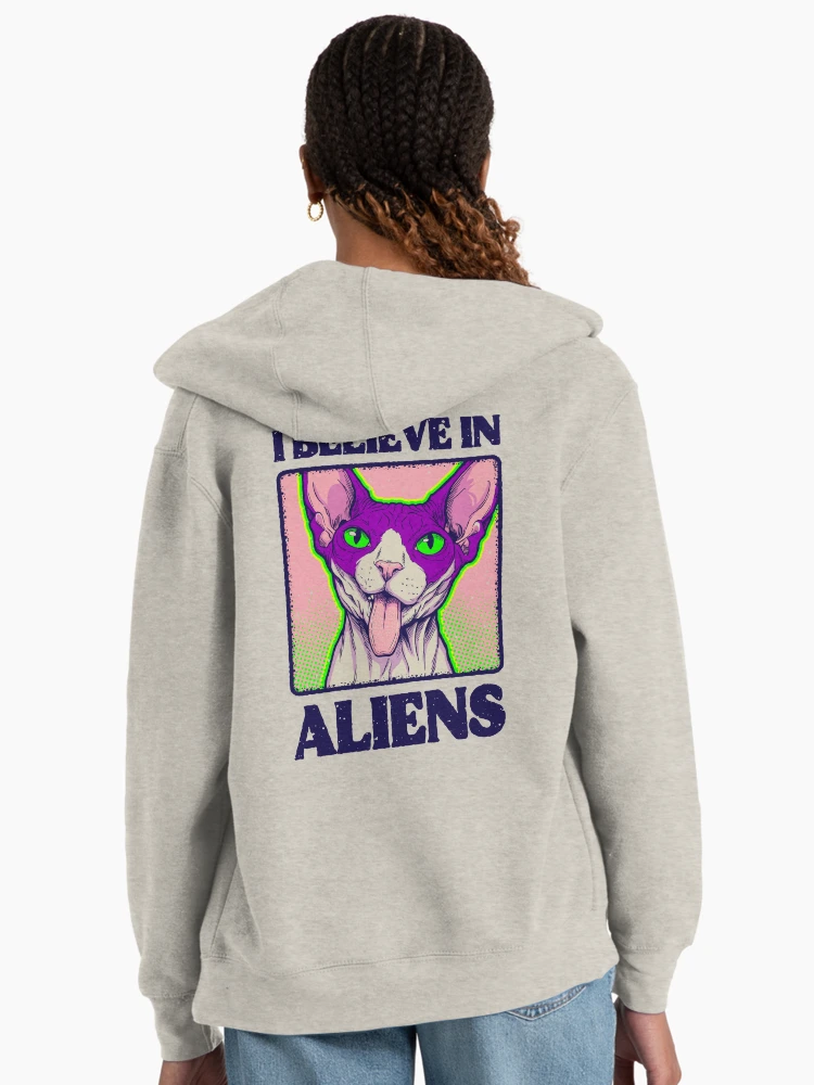 Woman seen from behind wearing a grey zip-up hoodie with a large alien cat spy design printed on the back.